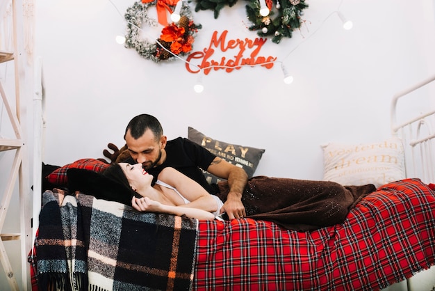 Pareja besándose en la cama