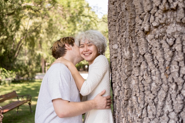 Pareja besándose y siendo romántico al aire libre