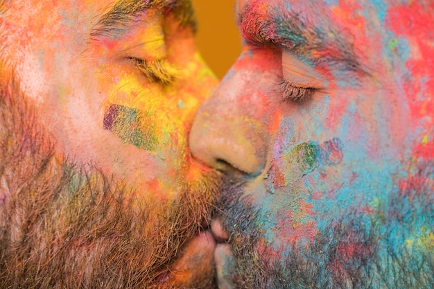 Pareja de besos de hombres homosexuales pintados con arcoiris.