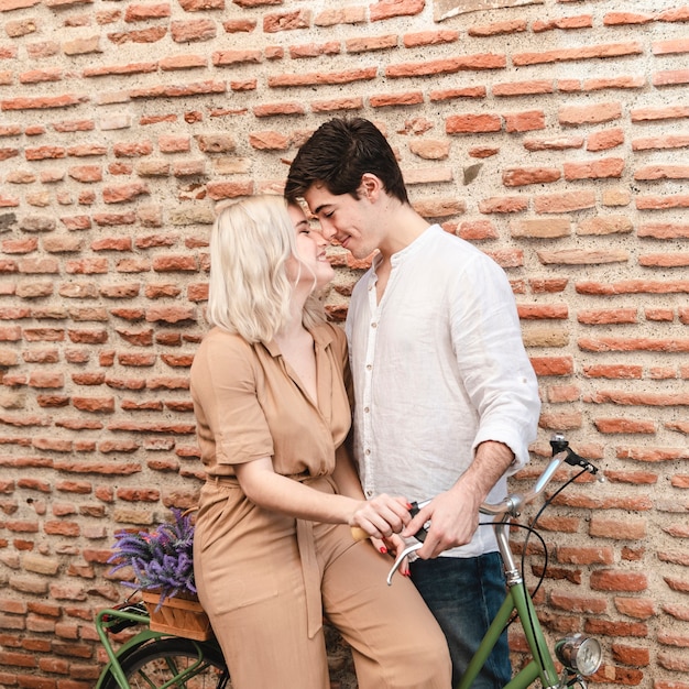 Foto gratuita pareja en bicicleta posando mientras se inclina para un beso