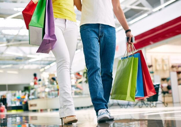 Pareja bien vestida caminando en el centro comercial