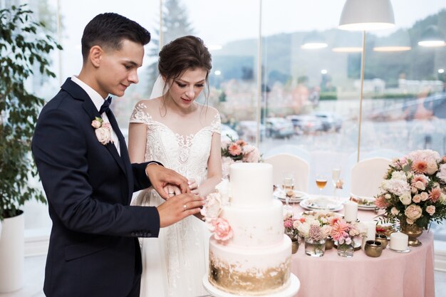 Pareja de boda cortando pastel de bodas