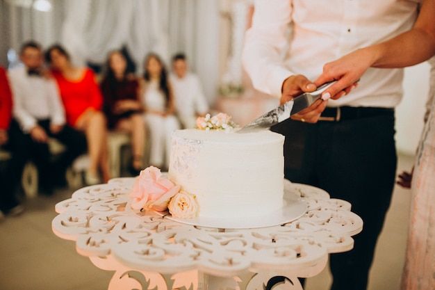 Foto gratuita pareja de boda cortando su pastel de boda