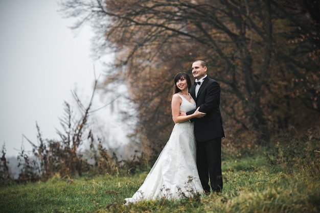 Pareja de la boda de pie en el campo