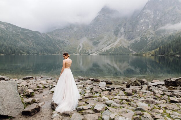 Pareja de boda romántica en pie de amor del lago Sea Eye en Polonia. Montes Tatra.