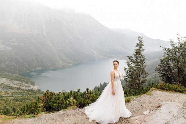 Pareja de boda romántica en pie de amor del lago Sea Eye en Polonia. Montes Tatra.