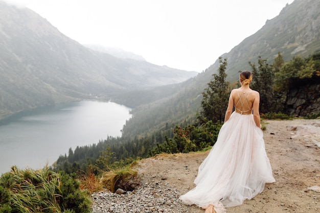 Pareja de boda romántica en pie de amor del lago Sea Eye en Polonia. Montes Tatra.