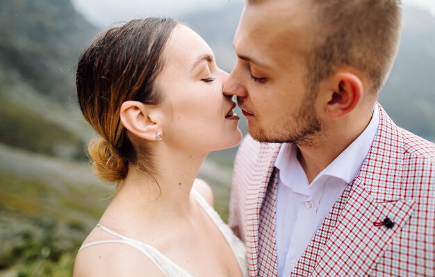 Pareja de boda romántica en pie de amor del lago Sea Eye en Polonia. Montes Tatra.