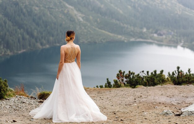 Pareja de boda romántica en pie de amor del lago Sea Eye en Polonia. Montes Tatra.