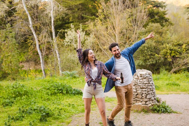 Pareja borracha divirtiéndose en el bosque