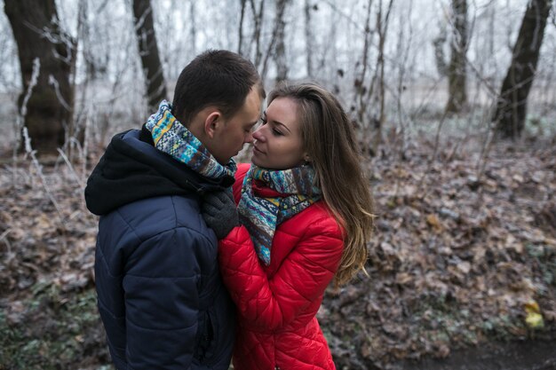 Pareja en bosque de invierno cerca del lago