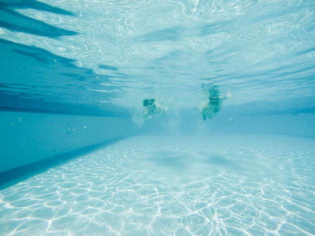 Pareja buceando en piscina