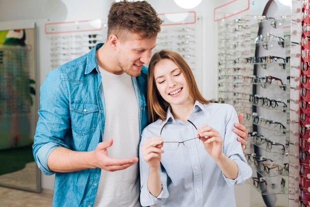 Pareja buscando gafas nuevas en óptico