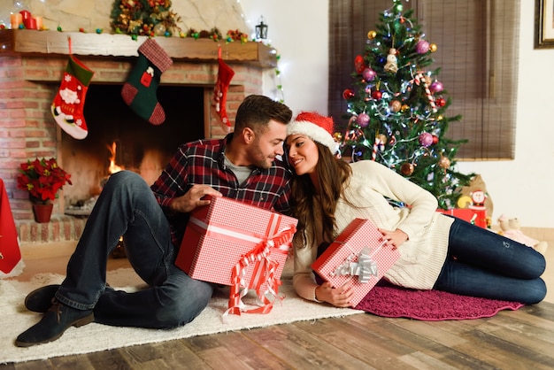 Pareja con cajas de regalos de navidad en su sala de estar