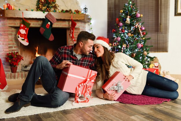 Pareja con cajas de regalos de navidad en su sala de estar