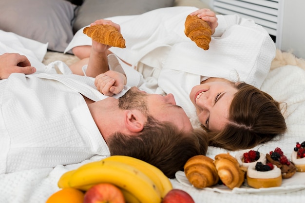 Pareja en la cama con croissants