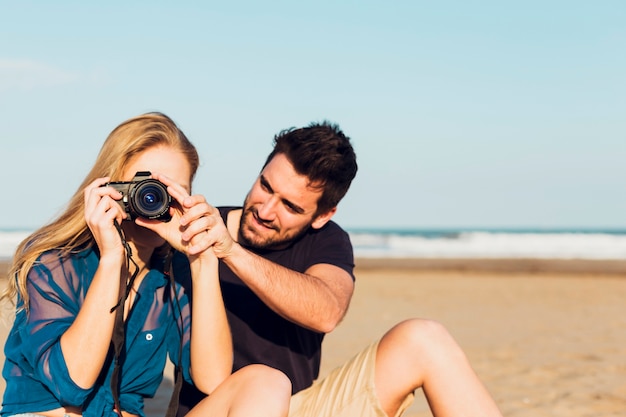 Foto gratuita pareja con cámara en la playa