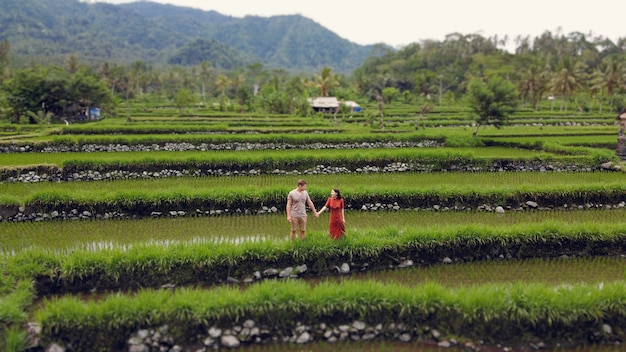 Pareja caminando en un campo de subida en un Bali