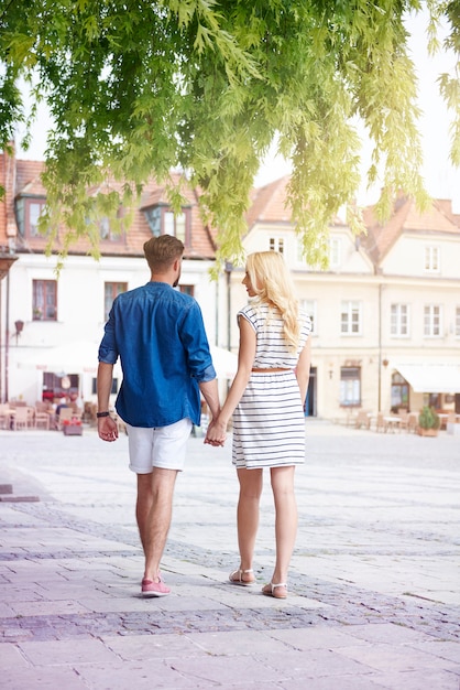 Pareja caminando en el casco antiguo en día de verano