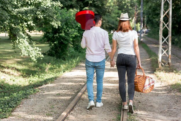 Pareja caminando a lo largo de las vías del tren