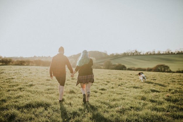 Pareja caminando y tomados de la mano al aire libre