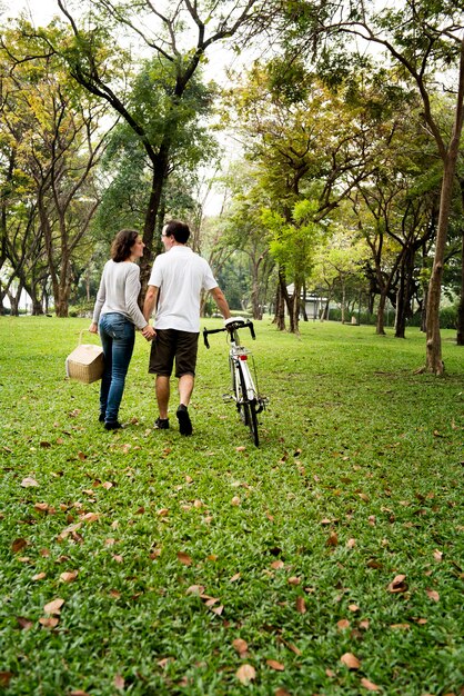 Pareja caminando y tomados de la mano en el parque