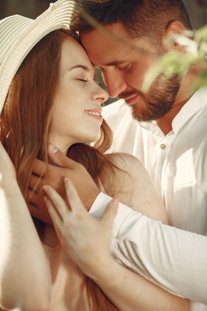 Pareja en un campo. Morena con camiseta blanca. Pareja sentada sobre un césped.