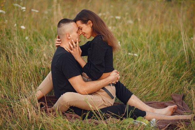 Pareja en un campo. Mujer con blusa negra.