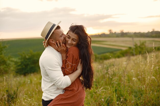 Pareja en un campo. Mujer con un vestido marrón.