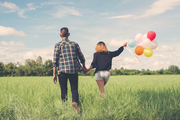 Pareja en un campo verde con globos