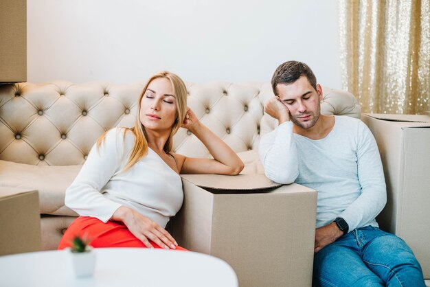 Pareja cansada en cajas