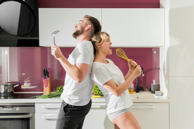 Pareja cantando en el interior de la cocina vista frontal