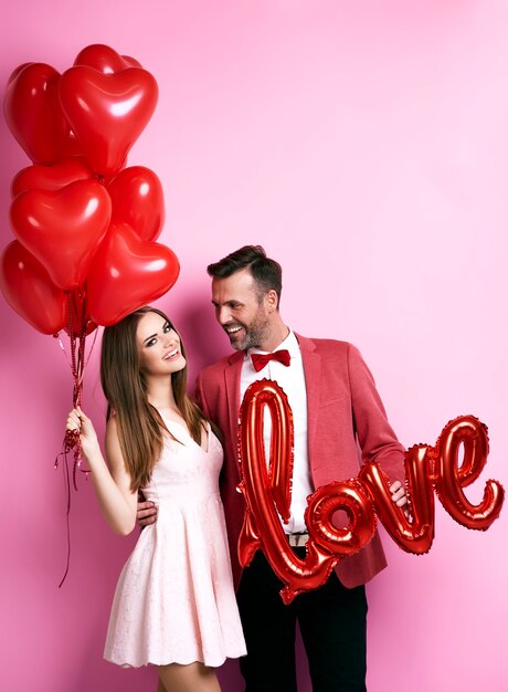 Foto gratuita pareja cariñosa con globos abrazando