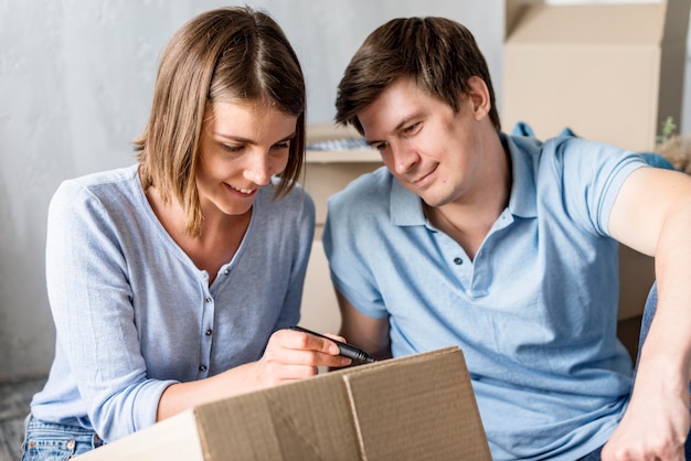 Foto gratuita pareja en casa en caja de etiquetado de día de la mudanza