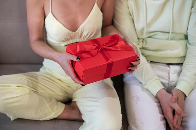 Pareja en casa celebrando el día de San Valentín con caja de regalo