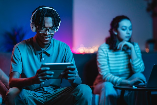 Pareja en casa junto con tableta y auriculares