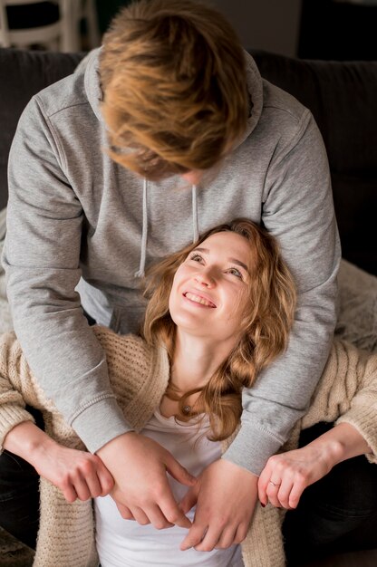 Pareja en casa sonriendo el uno al otro