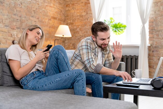 Pareja, en casa, teniendo, videollamada, con, familia