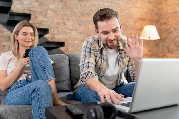 Pareja, en casa, teniendo, videollamada, con, familia