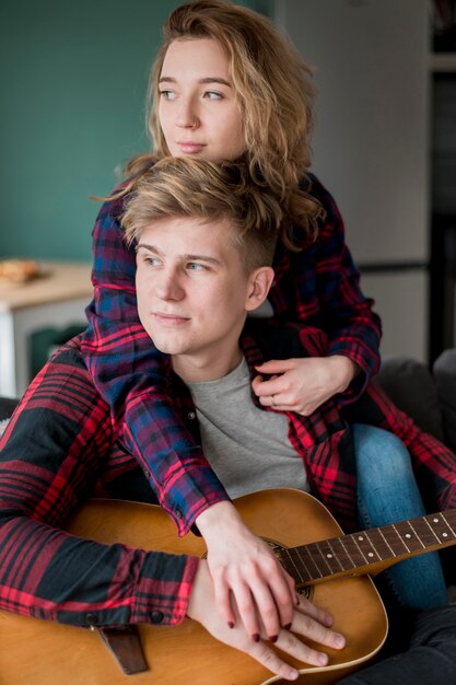 Pareja en casa tocando la guitarra