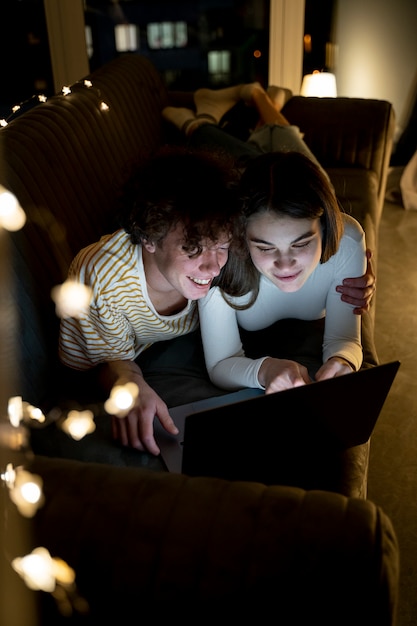 Pareja, en casa, usar la computadora portátil, juntos