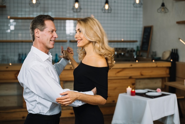 Pareja casada bailando durante una cena romántica