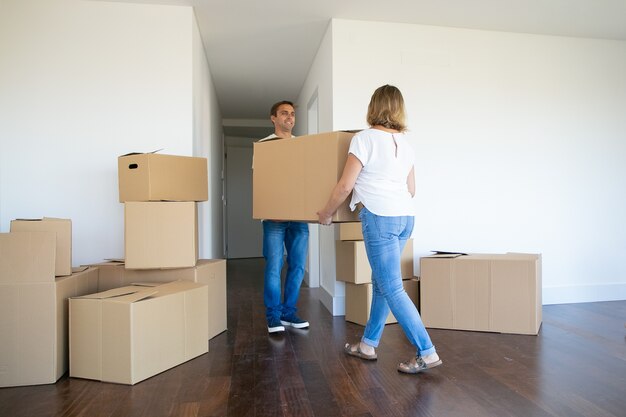 Pareja casada dejando el apartamento, llevando una caja de dibujos animados a la entrada