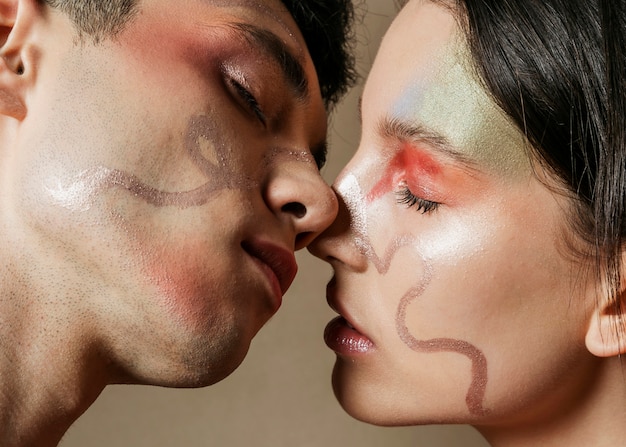 Pareja casi besándose con caras pintadas