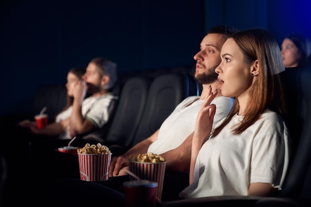 Pareja caucásica viendo una película de terror en el cine