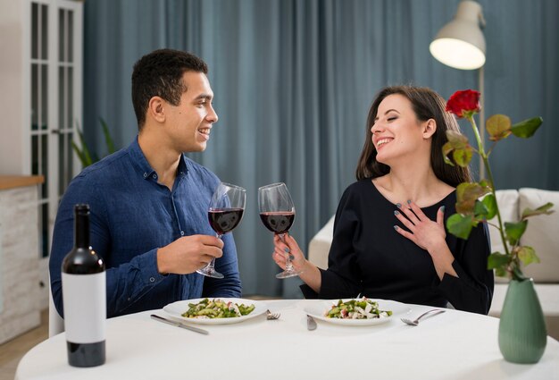 Foto gratuita pareja celebrando el día de san valentín con una botella de vino.