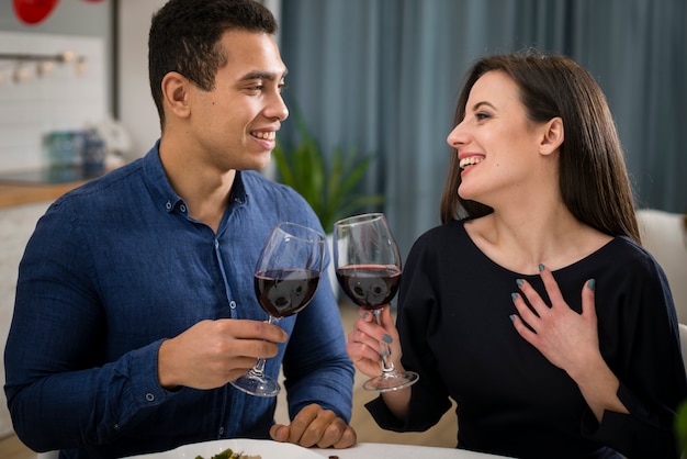 Pareja celebrando el día de San Valentín con una copa de vino.