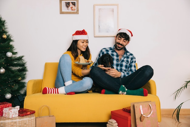 Pareja celebrando navidad en sofá