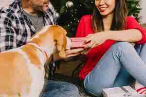 Foto gratuita pareja celebrando navidad con su perro