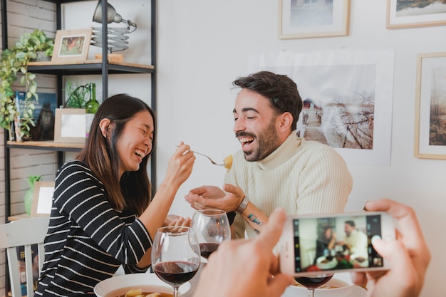 Pareja en cena de navidad en pantalla de smartphone